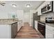 Modern kitchen featuring stainless steel appliances, granite countertops, and wood flooring at 5811 Rock Hollow Dr, Charlotte, NC 28212