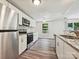 Bright kitchen boasts stainless steel appliances, granite counters, and a view to the outdoors at 5811 Rock Hollow Dr, Charlotte, NC 28212