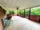 Covered porch with ceiling fan, chair, loveseat and nice outdoor views from the railing at 6229 Mountain Grove Rd, Hickory, NC 28602