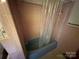 Angle view of a shower-tub combo with a light blue tub, pink tile, and shower curtain at 6229 Mountain Grove Rd, Hickory, NC 28602