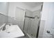 Bathroom featuring a glass shower door, gray stone floors and white marble tile walls at 706 Mcintyre St, Monroe, NC 28110