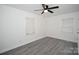 Bedroom featuring neutral walls, updated gray vinyl floors, ceiling fan and multiple windows at 706 Mcintyre St, Monroe, NC 28110