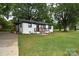 Inviting one-story house with a well-maintained lawn and a cozy front porch for relaxing outdoors at 706 Mcintyre St, Monroe, NC 28110