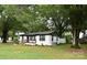 Charming single-story home with lush green lawn and mature trees providing ample shade at 706 Mcintyre St, Monroe, NC 28110