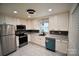 Modern kitchen featuring white cabinets, stainless steel appliances, granite countertops, and tiled backsplash at 706 Mcintyre St, Monroe, NC 28110