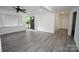 Bright living room featuring neutral walls, updated gray vinyl floors, ceiling fan and an open door entrance at 706 Mcintyre St, Monroe, NC 28110
