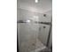 Close-up of a frameless glass shower featuring a gray stone floor and white marble tile walls at 706 Mcintyre St, Monroe, NC 28110
