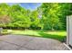 Spacious backyard with lush green grass, mature trees, and a stone patio perfect for outdoor enjoyment at 714 Deerbrook Ln, Tega Cay, SC 29708
