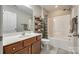 Bathroom featuring a wood vanity, a shower with a tub, and an open shelving unit for towels at 714 Deerbrook Ln, Tega Cay, SC 29708