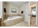 Bright bathroom showcasing a soaking tub with tile surround and a view to the bedroom at 714 Deerbrook Ln, Tega Cay, SC 29708