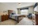 Relaxing bedroom featuring a wooden dresser, a cushioned chair, and large window with blinds at 714 Deerbrook Ln, Tega Cay, SC 29708