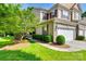 Inviting townhome exterior with lush green lawn, mature trees, and tidy shrubbery along the walkway at 714 Deerbrook Ln, Tega Cay, SC 29708
