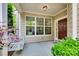Cozy front porch with a swing, a well-lit entryway, and verdant bushes creating a welcoming entrance at 714 Deerbrook Ln, Tega Cay, SC 29708