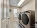 Modern laundry room featuring a front-loading washer and dryer set and tile flooring at 714 Deerbrook Ln, Tega Cay, SC 29708