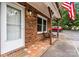 Brick home exterior with covered entrance, seating, and American flag at 729 Tenth Ne Ave, Hickory, NC 28601