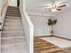 View of the living room featuring carpeted stairs, hardwood floors, and a ceiling fan at 729 Tenth Ne Ave, Hickory, NC 28601