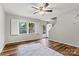 View of the living room featuring wood floors, a window with white shutters, and an entry door at 729 Tenth Ne Ave, Hickory, NC 28601