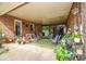 Relaxing covered patio, ideal for outdoor seating and entertainment, with plants and brick accents at 7518 Surry Ln, Indian Trail, NC 28079