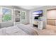 Bright bedroom featuring a work desk, mounted TV and decorative shelves at 7528 Red Oak Ln, Charlotte, NC 28226