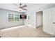 Neutral bedroom with a large window, ceiling fan, mounted TV, and bathroom access at 7528 Red Oak Ln, Charlotte, NC 28226