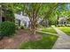 Inviting townhouse exterior with a well-kept lawn and mature trees offering shade and curb appeal at 7528 Red Oak Ln, Charlotte, NC 28226