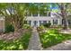 Charming townhouse with black shutters, a well-manicured lawn, and mature trees providing shade at 7528 Red Oak Ln, Charlotte, NC 28226