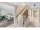 Hallway with stairs and view to a dining room with a table and chairs, featuring neutral decor at 7528 Red Oak Ln, Charlotte, NC 28226