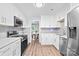 Modern kitchen with stainless steel appliances, white cabinetry, and granite countertops at 7528 Red Oak Ln, Charlotte, NC 28226