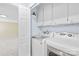 Functional laundry area with washer, dryer, and upper cabinets for storage solutions at 7528 Red Oak Ln, Charlotte, NC 28226