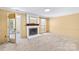 Spacious living room with a fireplace, neutral carpeting, and a door leading to an outdoor area at 7528 Red Oak Ln, Charlotte, NC 28226
