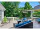 Lush outdoor deck with comfortable seating, a pergola, and a view of the wooded backyard at 8109 Hawk Crest Ct, Charlotte, NC 28270