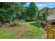 Lush backyard showcasing a well-maintained lawn, mature trees, and garden area; perfect for outdoor activities at 8109 Hawk Crest Ct, Charlotte, NC 28270