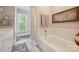 Bright bathroom featuring a soaking tub, large window, and coordinated neutral tones at 8109 Hawk Crest Ct, Charlotte, NC 28270