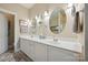 Well-lit bathroom featuring double vanities, oval mirrors, neutral tones, and tiled floors at 8109 Hawk Crest Ct, Charlotte, NC 28270