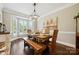 Bright dining room featuring hardwood floors, a bay window, and a rustic dining set at 8109 Hawk Crest Ct, Charlotte, NC 28270