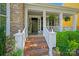 Welcoming front porch with brick steps, white railings, and lush landscaping at 8109 Hawk Crest Ct, Charlotte, NC 28270