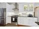 Modern kitchen featuring white cabinets, black counters, stainless steel appliances, and marble tile backsplash at 8109 Hawk Crest Ct, Charlotte, NC 28270