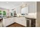 Bright kitchen boasts white cabinetry, black countertops, stainless steel appliances, and a farmhouse sink at 8109 Hawk Crest Ct, Charlotte, NC 28270