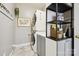 Functional laundry room with stacked washer/dryer and gray cabinets with stylish shelving at 8109 Hawk Crest Ct, Charlotte, NC 28270