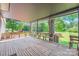 Spacious covered back deck featuring wood flooring and benches overlooks private backyard and mature trees at 8255 Castor Rd, Salisbury, NC 28146