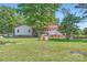 Exterior view of home showcasing red roof and spacious backyard with brick structure and mature trees at 8255 Castor Rd, Salisbury, NC 28146