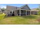 Spacious backyard featuring a screened-in porch, lush green lawn, and privacy at 9435 Liberty Hill Dr, Mint Hill, NC 28227