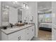 Bathroom with double vanity, stylish fixtures, and a view into the bedroom at 9435 Liberty Hill Dr, Mint Hill, NC 28227