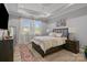 Serene bedroom with a tray ceiling, hardwood floors, large windows, and elegant furnishings at 9435 Liberty Hill Dr, Mint Hill, NC 28227