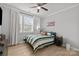 Cozy bedroom with a ceiling fan, large window, and wood flooring at 9435 Liberty Hill Dr, Mint Hill, NC 28227