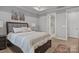 Comfortable bedroom with tray ceiling, hardwood floors, and a view into the ensuite bathroom at 9435 Liberty Hill Dr, Mint Hill, NC 28227