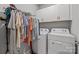 Bright laundry room with washer, dryer, storage cabinets, and hanging rack at 9435 Liberty Hill Dr, Mint Hill, NC 28227
