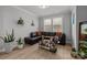 Living room with a leather couch, indoor plants, and a sunny window at 9435 Liberty Hill Dr, Mint Hill, NC 28227