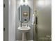 Powder room with a pedestal sink, mirror, and decorative accents at 9435 Liberty Hill Dr, Mint Hill, NC 28227