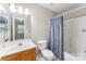 Cozy bathroom featuring a vanity sink, toilet, tub, patterned shower curtain and a mirror at 10223 Reindeer Way Ln, Charlotte, NC 28216